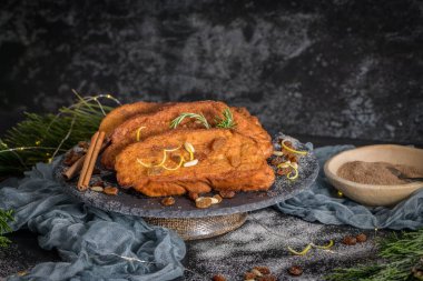 Traditional Christmas Rabanadas with lemon zest, raisins, pine nuts and cinnamon. Spanish Torrijas or french toasts close up on the countertop