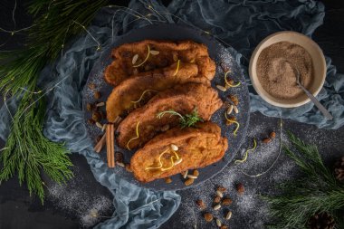 Traditional Christmas Rabanadas with lemon zest, raisins, pine nuts and cinnamon. Spanish Torrijas or french toasts close up on the countertop