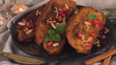 Traditional Christmas Rabanadas with pommegranate seeds, pine nuts and cinnamon. Spanish Torrijas or french toasts close up on the countertop.