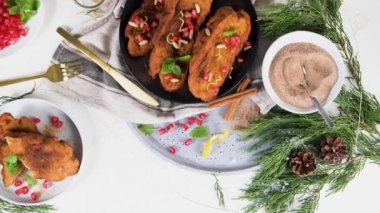 Traditional Christmas Rabanadas with pommegranate seeds, pine nuts and cinnamon. Spanish Torrijas or french toasts close up on the countertop.