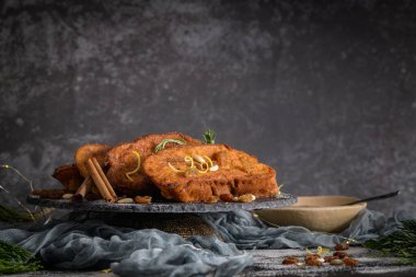 Traditional Christmas Rabanadas with lemon zest, raisins, pine nuts and cinnamon. Spanish Torrijas or french toasts close up on the countertop