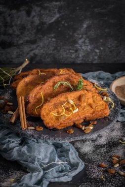 Traditional Christmas Rabanadas with lemon zest, raisins, pine nuts and cinnamon. Spanish Torrijas or french toasts close up on the countertop