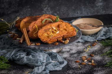 Traditional Christmas Rabanadas with lemon zest, raisins, pine nuts and cinnamon. Spanish Torrijas or french toasts close up on the countertop