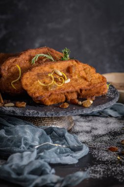 Traditional Christmas Rabanadas with lemon zest, raisins, pine nuts and cinnamon. Spanish Torrijas or french toasts close up on the countertop