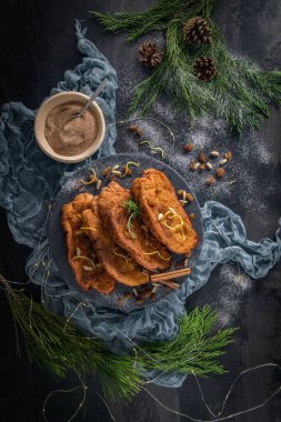 Traditional Christmas Rabanadas with lemon zest, raisins, pine nuts and cinnamon. Spanish Torrijas or french toasts close up on the countertop