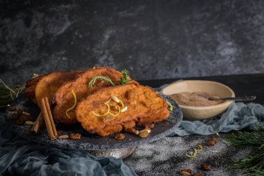 Traditional Christmas Rabanadas with lemon zest, raisins, pine nuts and cinnamon. Spanish Torrijas or french toasts close up on the countertop