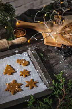 Noel kurabiyeleri için çiğ hamur ve ahşap mutfak tezgahında kurabiye keskisi..