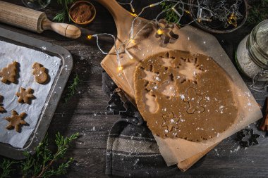Noel kurabiyeleri için çiğ hamur ve ahşap mutfak tezgahında kurabiye keskisi..