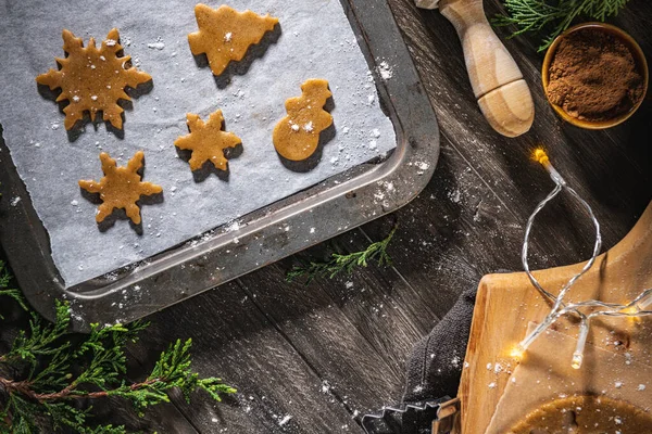 Noel kurabiyeleri için çiğ hamur ve ahşap mutfak tezgahında kurabiye keskisi..