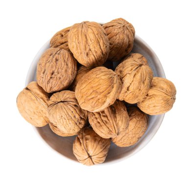 Kabuklu cevizler beyaz arka planda izole edilmiş beyaz fındık kasesi üst görünümü.