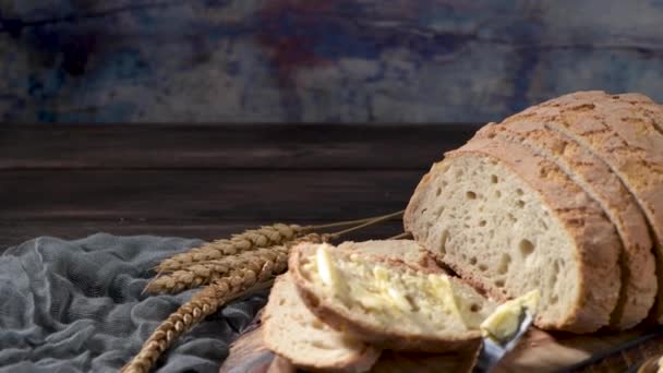 Смазанный Кусочек Свежеиспеченного Хлеба Пшеницы Ножом Масла Деревенской Доске — стоковое видео