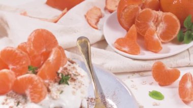 Yulaf, kekik ve nane yapraklarıyla modern mutfak tezgahında yoğurt ve mandalinalı krep..