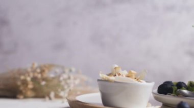 Kivili Chia pudingi, yabanmersini ve hindistan cevizi dilimleri, beyaz bir masada cam kavanozlarda üç porsiyon..