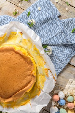 Portekiz sünger keki pişirmede kullanılan tipik kağıda sarılmış, ahşap zemin üzerinde boyanmış paskalya yumurtası süslemesi..