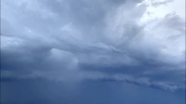 Koyu gri fırtına bulutları. Dramatik bir gökyüzü. Kara fırtınalı bulutlarda aydınlatma. Gün batımında güzel doğa fırtınası bulutlarını hızlandırıyor. Korkunç bir hava.