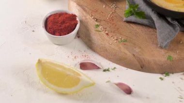 Seramik kasede nefis humus. Beyaz arkaplanda renkli abur cubur kompozisyonu.