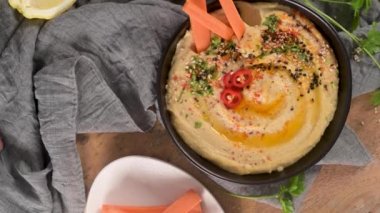 Seramik kasede nefis humus. Beyaz arkaplanda renkli abur cubur kompozisyonu.