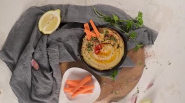 Seramik kasede nefis humus. Beyaz arkaplanda renkli abur cubur kompozisyonu.