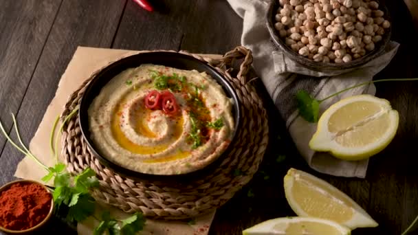 Hummus Delicioso Tigela Cerâmica Composição Lanche Colorido Fundo Madeira Preta — Vídeo de Stock