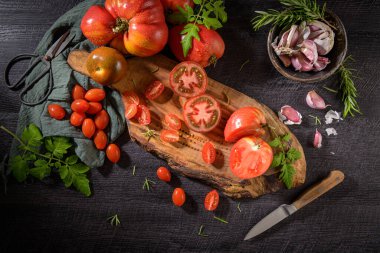 Mutfak tezgahında çok çeşitli domatesler var. Domates sosunun hazırlanması.