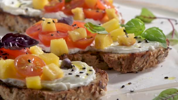 Italienische Bruschettas Mit Gerösteten Tomaten Mozzarella Ananasscheiben Und Kräutern Auf — Stockvideo