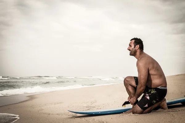 Surfista atando la lixiviación de su tabla de surf —  Fotos de Stock