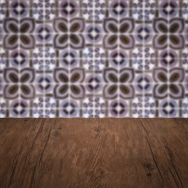 Wood table top and blur vintage ceramic tile pattern wall — Stock Photo, Image