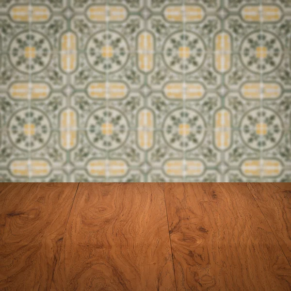 Wood table top and blur vintage ceramic tile pattern wall — Stock Photo, Image