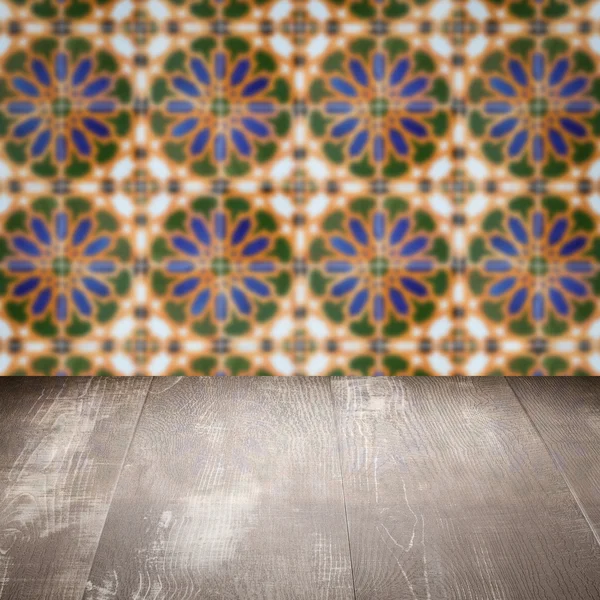 Wood table top and blur vintage ceramic tile pattern wall — Stock Photo, Image