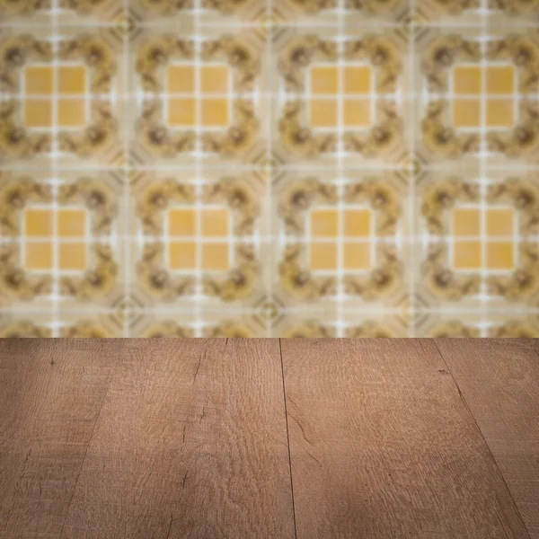 Wood table top and blur vintage ceramic tile pattern wall — Stock Photo, Image