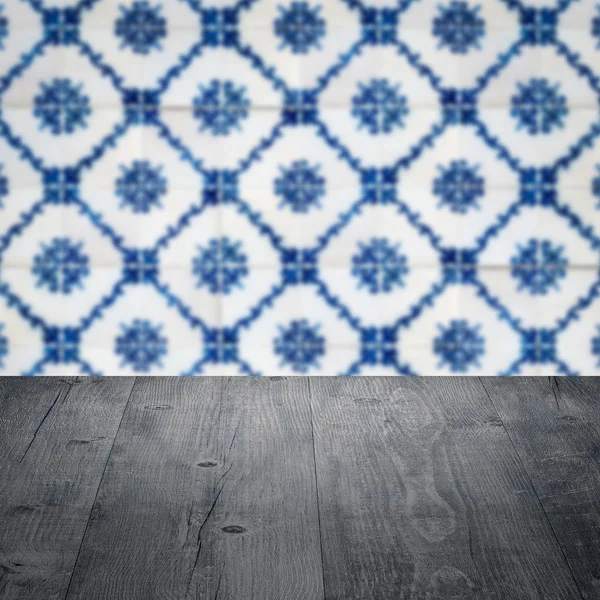 Wood table top and blur vintage ceramic tile pattern wall — Stock Photo, Image