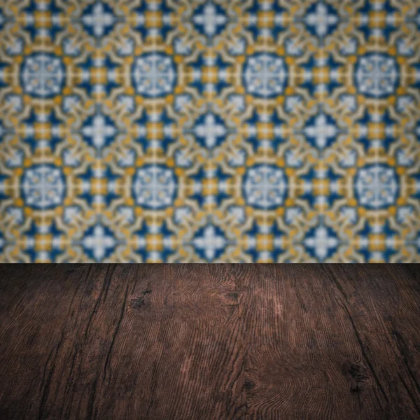 Wood table top and blur vintage ceramic tile pattern wall — Stock Photo, Image