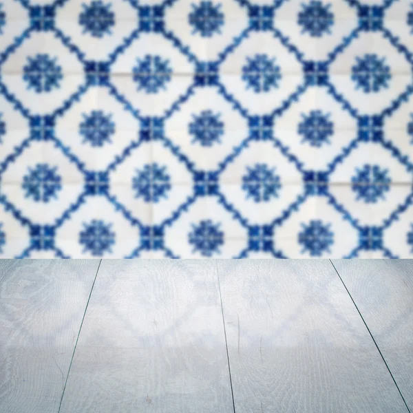 Wood table top and blur vintage ceramic tile pattern wall — Stock Photo, Image