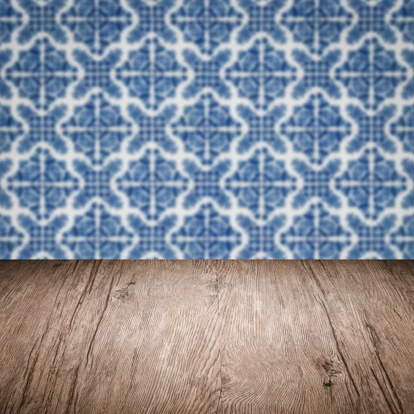 Wood table top and blur vintage ceramic tile pattern wall — Stock Photo, Image