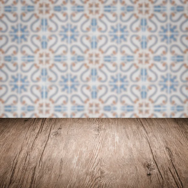 Wood table top and blur vintage ceramic tile pattern wall — Stock Photo, Image