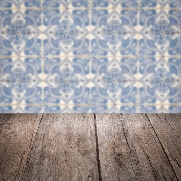 Wood table top and blur vintage ceramic tile pattern wall — Stock Photo, Image