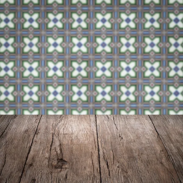 Wood table top and blur vintage ceramic tile pattern wall — Stock Photo, Image