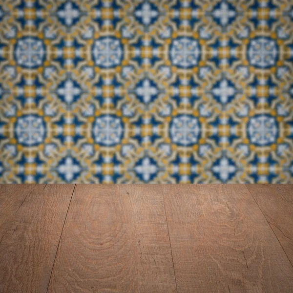 Wood table top and blur vintage ceramic tile pattern wall — Stock Photo, Image