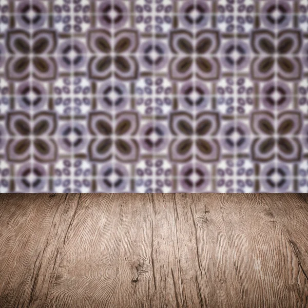 Wood table top and blur vintage ceramic tile pattern wall — Stock Photo, Image