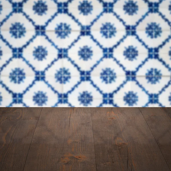 Wood table top and blur vintage ceramic tile pattern wall — Stock Photo, Image