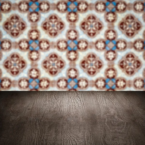 Wood table top and blur vintage ceramic tile pattern wall — Stock Photo, Image