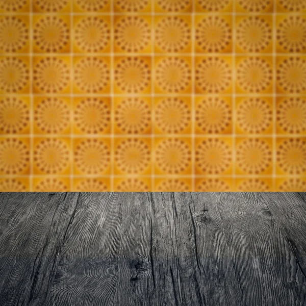 Wood table top and blur vintage ceramic tile pattern wall — Stock Photo, Image