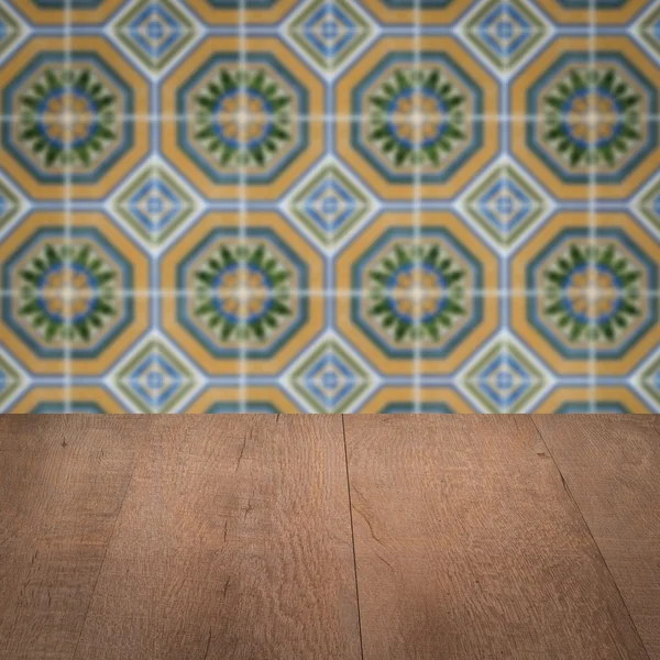 Wood table top and blur vintage ceramic tile pattern wall — Stock Photo, Image