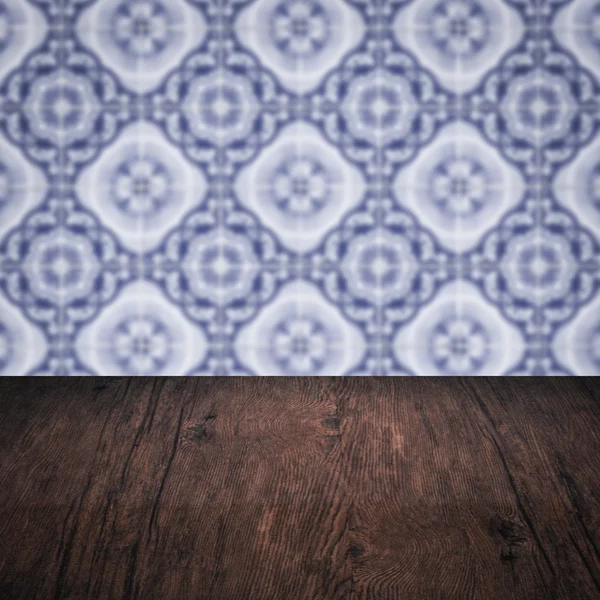 Wood table top and blur vintage ceramic tile pattern wall — Stock Photo, Image