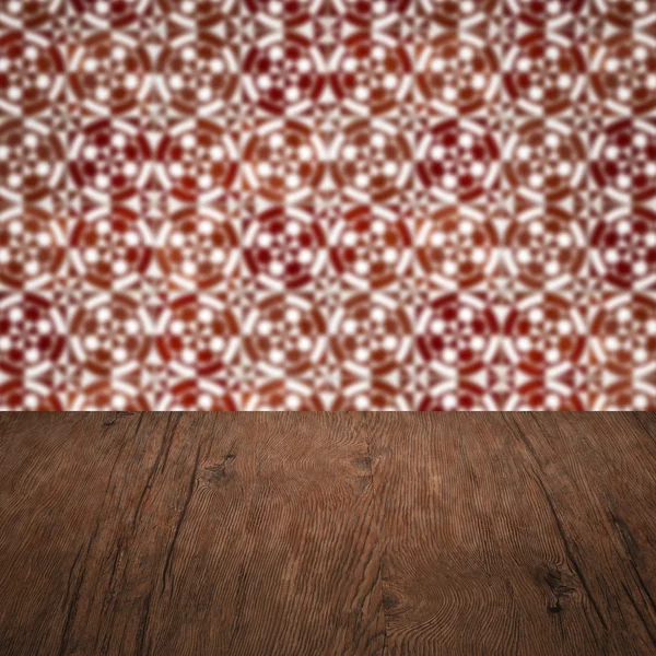 Wood table top and blur vintage ceramic tile pattern wall — Stock Photo, Image