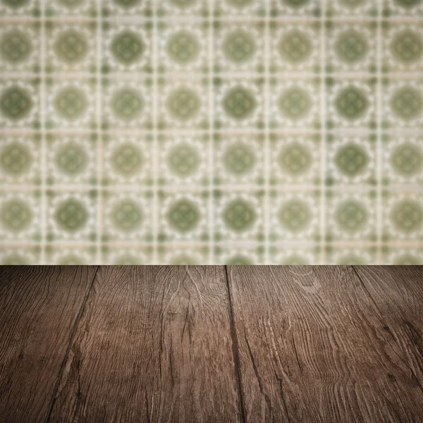 Wood table top and blur vintage ceramic tile pattern wall — Stock Photo, Image