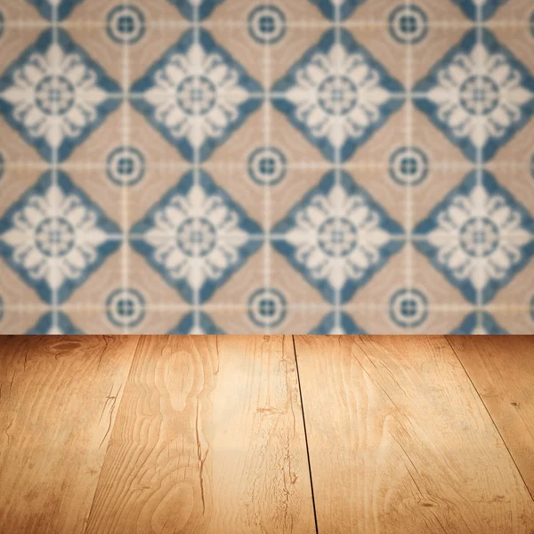 Wood table top and blur vintage ceramic tile pattern wall — Stock Photo, Image