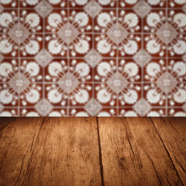 Wood table top and blur vintage ceramic tile pattern wall — Stock Photo, Image