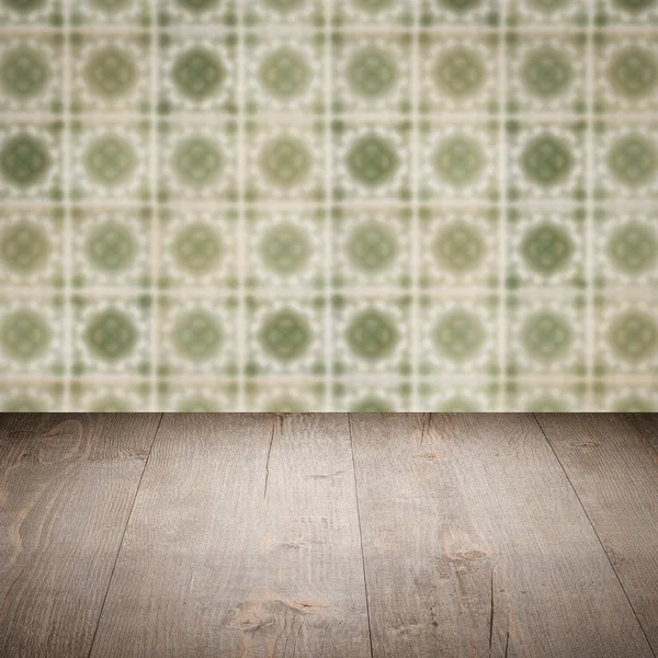 Wood table top and blur vintage ceramic tile pattern wall — Stock Photo, Image