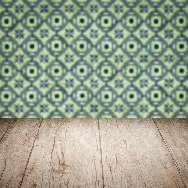 Wood table top and blur vintage ceramic tile pattern wall — Stock Photo, Image